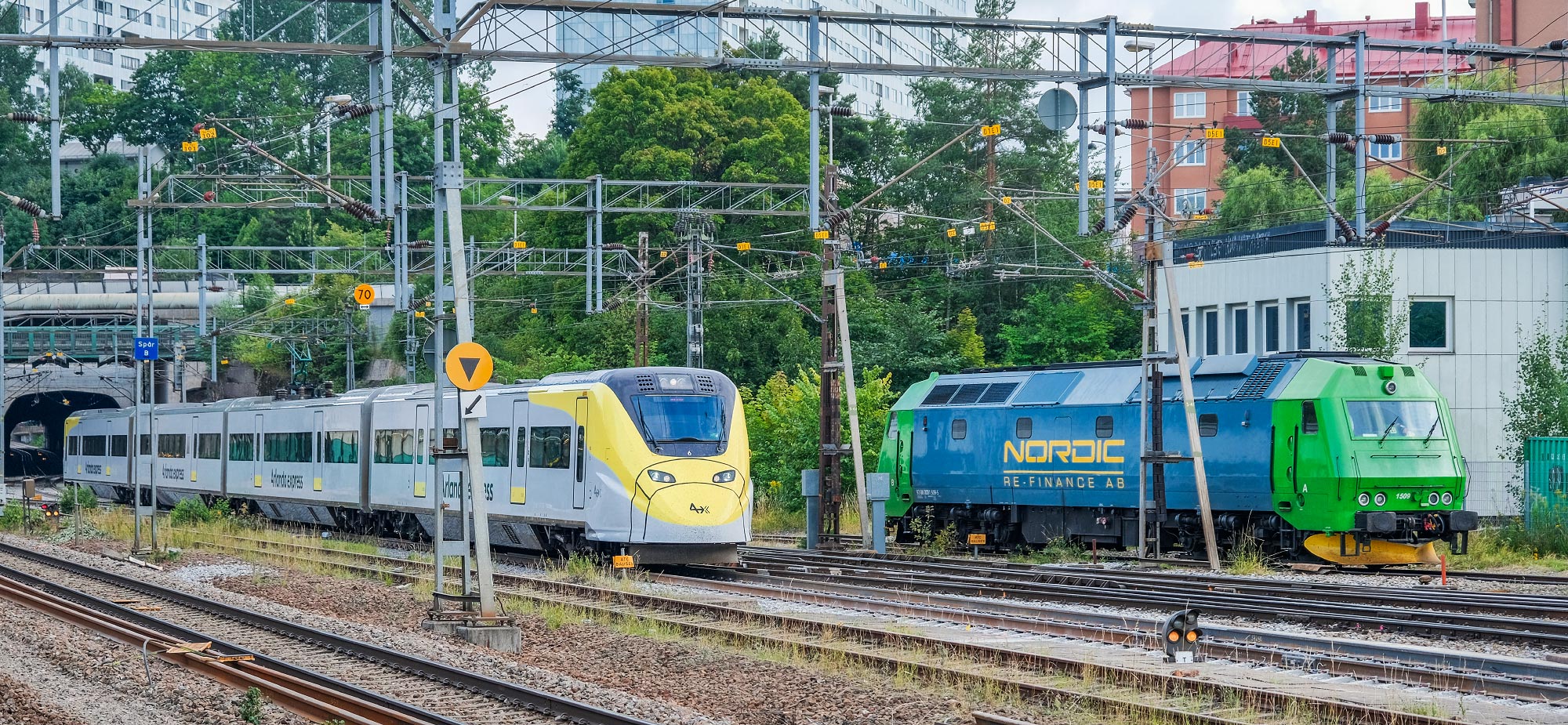 Nordic Re-Finance TME 1509, uthyrt till ProTrain som bärgningslok, väntar på nya uppdrag medan en X3-motorvagn passerar